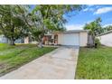 Charming single-story home featuring a front lawn and an attached two-car garage at 7040 Fox Hollow Dr, Port Richey, FL 34668