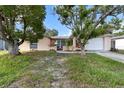 Charming single-story home featuring a front lawn and an attached two-car garage at 7040 Fox Hollow Dr, Port Richey, FL 34668
