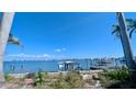Beautiful waterfront view with a partially collapsed pier, palm trees, and calm blue water at 720 Boca Ciega Isle Dr, St Pete Beach, FL 33706