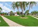 Single story home with a lush green lawn, showcasing curb appeal and mature landscaping for a serene setting at 8635 Chadwick Dr, Tampa, FL 33635