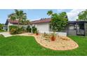 Beautiful home exterior with a well-manicured lawn and decorative rock garden at 8635 Chadwick Dr, Tampa, FL 33635
