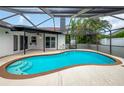 Inviting screened-in pool with multiple entry steps and a view of the blue sky; a perfect backyard oasis at 8635 Chadwick Dr, Tampa, FL 33635