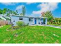 Well-kept single-story home featuring a blue exterior, lush green lawn, and inviting front entrance at 10436 117Th Dr, Largo, FL 33773
