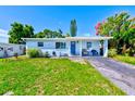 Quaint single-Gathering home with a well-maintained lawn, blue exterior, and a welcoming entrance at 10436 117Th Dr, Largo, FL 33773