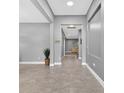 Bright hallway features sleek grey tile flooring and leads to other rooms at 11325 78Th E St, Parrish, FL 34219