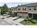 Street view of townhomes with manicured lawns, garages, and neutral exteriors on a sunny day at 11916 Castine St, New Port Richey, FL 34654