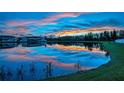 Scenic lake view reflects the colorful sunset, enhancing this beautiful property at 12025 Greengate Dr, Hudson, FL 34669