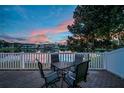 Outdoor patio with table and chairs offers serene lake views at sunset at 12025 Greengate Dr, Hudson, FL 34669