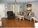 Cozy living room features a modern ceiling fan, neutral walls, and sleek laminate wood flooring at 12411 Brookside St, Spring Hill, FL 34609