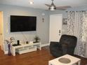 Comfortable living room with neutral walls, a flat screen tv, a comfortable recliner, and modern decor at 12411 Brookside St, Spring Hill, FL 34609