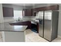 Modern kitchen featuring stainless steel appliances, dark wood cabinetry, granite countertops, and a stylish backsplash at 1309 29Th S St, St Petersburg, FL 33712