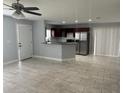Open-concept living room next to kitchen featuring a ceiling fan, tile flooring, and ample natural light at 1309 29Th S St, St Petersburg, FL 33712
