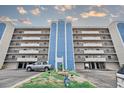 View of the building's exterior, featuring private balconies and covered parking at 14300 Gulf Blvd # 104, Madeira Beach, FL 33708