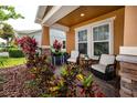 Cozy front porch with stone pillars and colorful plants creating a welcoming outdoor space at 1601 Fox Grape Loop, Lutz, FL 33558
