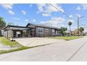 View of the home's side and attached carport featuring ample parking space and additional storage at 1701 N Tampania Ave, Tampa, FL 33607