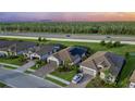 Aerial view of homes with tile roofs, paved driveways, and backyard solar panels on a sunny day at 20828 Cattail Blvd, Venice, FL 34292