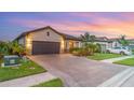 Single-story home featuring a tile roof, paved driveway, and well-maintained landscaping with stone accents at 20828 Cattail Blvd, Venice, FL 34292