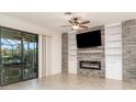 Living room featuring a stone accent wall with a fireplace, built-in shelving, and a sliding glass door at 20828 Cattail Blvd, Venice, FL 34292