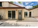 A back patio with a sliding glass door and a decorative glass front door offers outdoor living at 2095 Sunset Point Rd # 2201, Clearwater, FL 33765