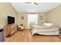 Bright bedroom features a ceiling fan, and an area with furniture near a window at 26616 Whirlaway Ter, Wesley Chapel, FL 33544