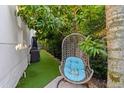 Cozy backyard nook featuring a hanging chair, artificial turf, and shaded by mature trees at 2711 W Trilby Ave, Tampa, FL 33611