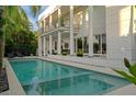 Gorgeous in-ground pool with an integrated spa, surrounded by tropical landscaping and a covered patio at 2711 W Trilby Ave, Tampa, FL 33611