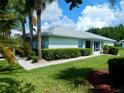 The exterior features lush green grass and beautiful hedges, enhancing the home's curb appeal at 29413 Caddyshack Ln, San Antonio, FL 33576