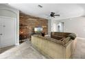 Comfortable living room featuring tile floors, a wood accent wall, and ample seating at 4079 Pacente Loop, Wesley Chapel, FL 33543