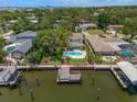 Expansive backyard with a pool, patio and waterfront access with a private dock in this aerial view at 4146 Harbor Hills Dr, Largo, FL 33770