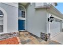Charming entryway with a blue front door, stone accents, and decorative tile walkway at 4634 Mapletree Loop, Wesley Chapel, FL 33544