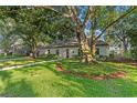 Well-manicured front lawn with mature trees and quaint landscaping at 4708 W Neptune St, Tampa, FL 33629