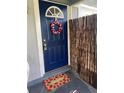 Beautiful blue front door with a decorative wreath and strawberry welcome mat at 4721 W Wallace Ave, Tampa, FL 33611