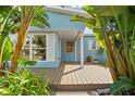 Inviting front porch featuring a wood deck and lush tropical landscaping at 605 Bosphorous Ave, Tampa, FL 33606