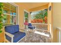 Inviting front porch with comfortable seating, flower arrangement, and bright, natural light at 621 Winterside Dr, Apollo Beach, FL 33572
