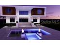 Modern home with a luxurious pool featuring fire bowls, offering a stylish outdoor space at 7849 Marsh Pointe Dr, Tampa, FL 33635