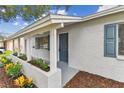 Inviting front porch with white columns, blue door and shutters, and fresh landscaping at 9936 62Nd N St, Pinellas Park, FL 33782