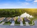 An aerial daytime view of a community of homes, with a pond and treelined backdrop at 11597 Weaver Hollow Rd, New Port Richey, FL 34654