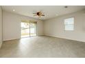 Bright living room featuring tile flooring, recessed lighting, and sliding glass doors to the backyard at 13408 Nimble Minke # 155E, Riverview, FL 33579
