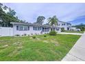 Charming single-story home featuring a well-manicured lawn and beautiful landscaping in the front yard at 1445 Coburn Dr, Tarpon Springs, FL 34689