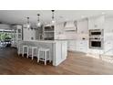 Modern white kitchen with large island, stainless steel appliances, and pendant lighting at 15316 Winding Creek Dr, Tampa, FL 33613
