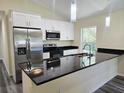 Modern kitchen featuring stainless steel appliances, granite countertops, and sleek white cabinetry at 1565 S Martin Luther King Jr Ave, Clearwater, FL 33756