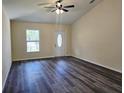 Bright living room featuring vaulted ceiling, ceiling fan and attractive wood-look flooring at 1565 S Martin Luther King Jr Ave, Clearwater, FL 33756