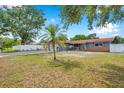 Expansive front yard with a charming single-story home, lush lawn, mature trees, and a circular driveway at 1710 Townsend St, Clearwater, FL 33755