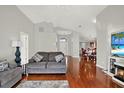 Living room featuring vaulted ceilings, beautiful hardwood floors, and a neutral color scheme at 18419 Merseyside Loop, Land O Lakes, FL 34638