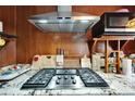 Close-up of a kitchen stove with stainless steel vent hood, complemented by granite countertops at 2334 14Th N Ave, St Petersburg, FL 33713