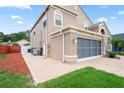 Side view of a two-story home with a brick driveway and well-manicured lawn at 277 Wood Dove Avenue, Tarpon Springs, FL 34689