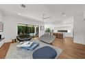 Open-concept living room features modern furnishings, hardwood floors, and seamless indoor-outdoor flow to the pool at 2803 W Aquilla St, Tampa, FL 33629