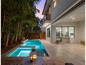 Backyard features a modern pool and spa, surrounded by lush landscaping, perfect for outdoor entertaining at 2803 W Aquilla St, Tampa, FL 33629