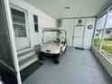 Carport featuring a golf cart parked next to a door labeled 'SeaBound' at 34645 Camphor N Dr, Pinellas Park, FL 33781