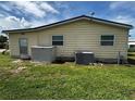 Side view of the home showcasing the fenced backyard, exterior door, two windows and AC Unit at 35020 Colony Hills Dr, Zephyrhills, FL 33541